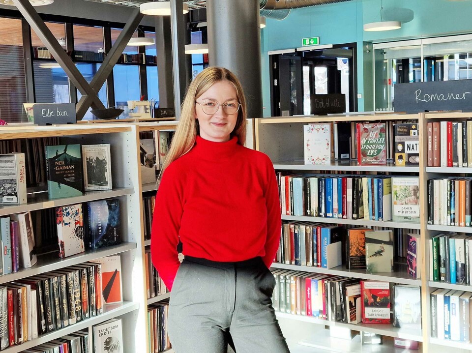 Trine Sivertsen blant hyllene på Vågan bibliotek under praksisperioden i hjembygda vinteren 2023.