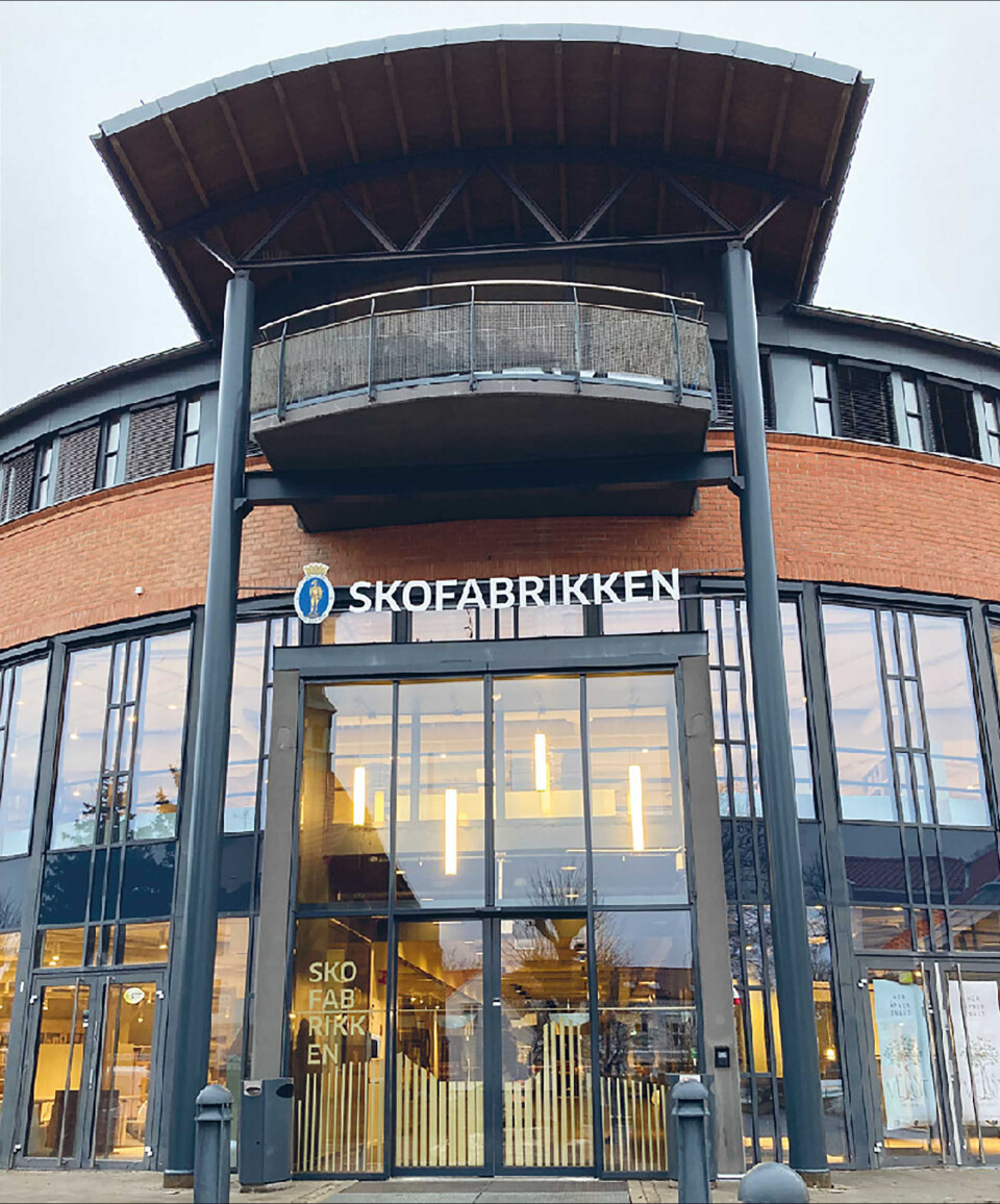Fasaden minner om at bygget i senere tid var et kjøpesenter. Men i sjelettet til dagens flerbrukshus ligger en skofabrikk
