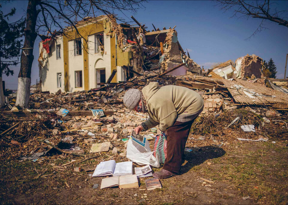 Ei kvinne frå landsbyen Bysjiv ser på bøker nær eit øydelagt bibliotek i utkanten av Kyiv 25. mars.