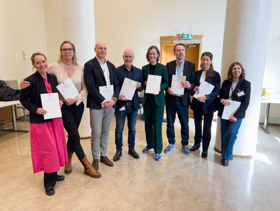 Kulturministeren i grøn dress flankert av representantar for interesseorganisasjonar i bokfeltet.