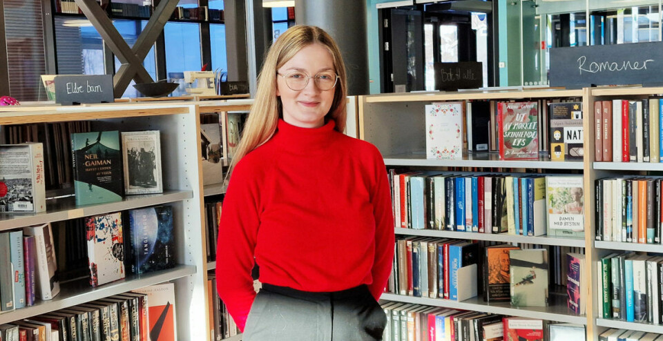 Trine Sivertsen blant hyllene på Vågan bibliotek under praksisperioden i hjembygda vinteren 2023.