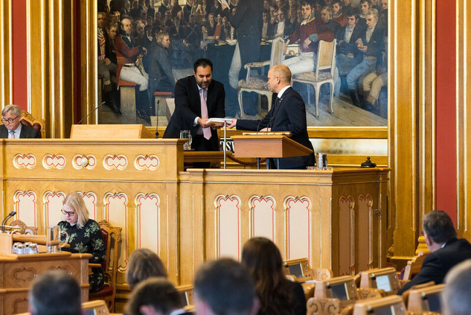 Finansminister Trygve Slagsvold Vedum (Sp) overleverer statsbudsjettet for 2023 til stortingspresident Masud Gharahkhani. Bilde fra Stortingssalen