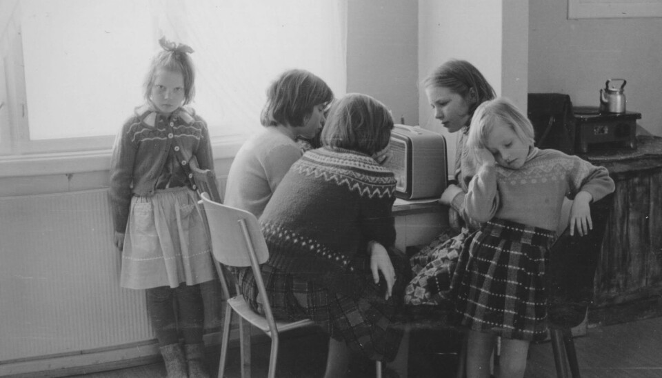 Sammen: Barn ved Sarnes internatskole i Nordkapp kommune rundt radioapparatet for å høre på barnetimen en gang på midten av 1900-tallet.