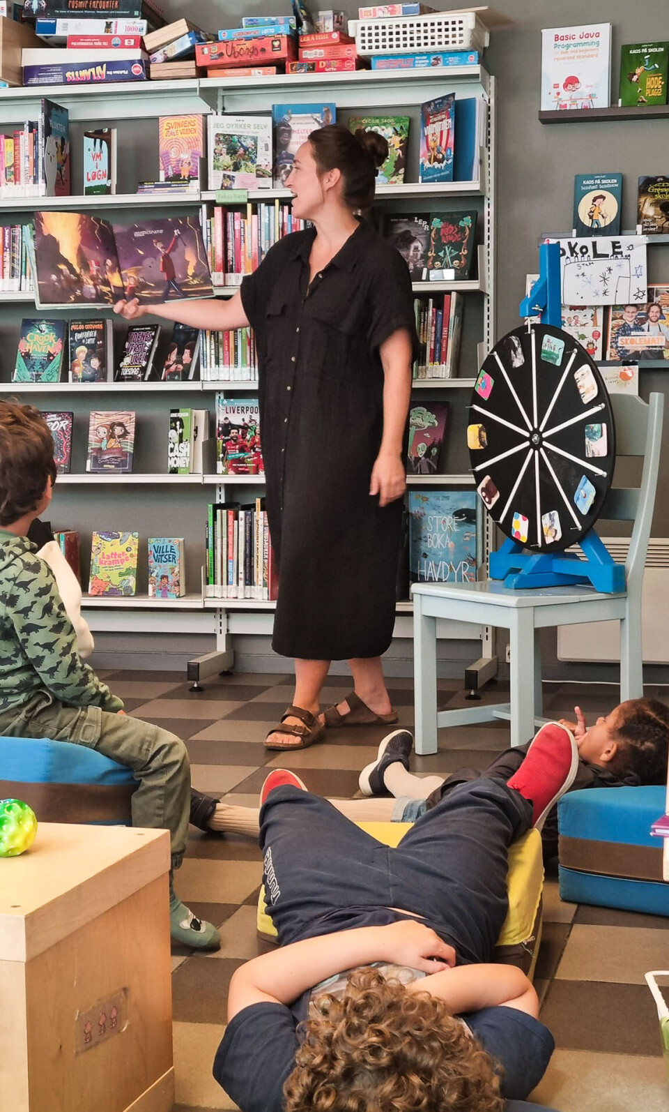 Bibliotekar Oda Øverbø snurrer leselykkehjulet sammen med ivrige tilhørere .