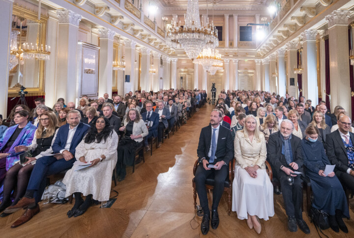 På slottet: Rundt 250 personar overvar Fosseforedraget og utdelinga av Fosseprisen torsdag 24. april. Lengre bak til høgre: Ragnhild Malfang frå Lillestrømbibliotekene, Trine Schøning frå Bærum bibliotek, Jørgen Hovde frå Drammen bibliotek og mange fleir bibliotekfolk. På første rad frå venstre: Musikar Anja Lauvdal, direktør i NORLA Margit Walsø, nasjonalbibliotekar Aslak Sira Myhre, kultur- og likestillingsminister Lubna Jaffery, kronprins Haakon Magnus, kronprinsesse Mette-Marit, Jon Fosse, Anna Fosse og omsettarprisvinnar Hinrich Schmidt-Henkel.