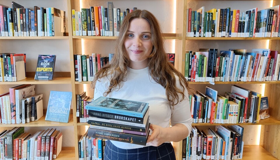 Kortliste: Prosjektleder Hanne Rømsing Sæverås ved Bergen Offentlige Bibliotek viser frem de åtte bøkene som er nominert til Bibliotekets litteraturpris 2025.