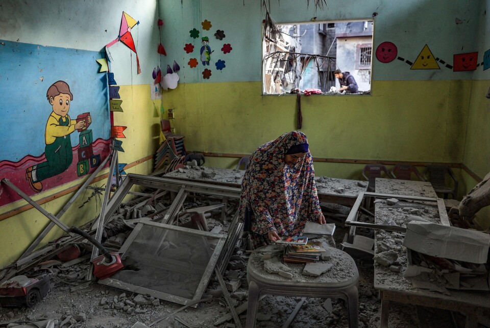 Hvor lenge? En kvinne prøver å berge noen bøker i en barnehage rammet av israelsk bombing i Rafah sør på Gazastripen 9. desember 2023. Da hadde krigen pågått i to måneder. Nå har den snart pågått i to år.