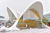 Tromsø bibliotek med hvite buede tak og glassfasade i et snødekt bymiljø.